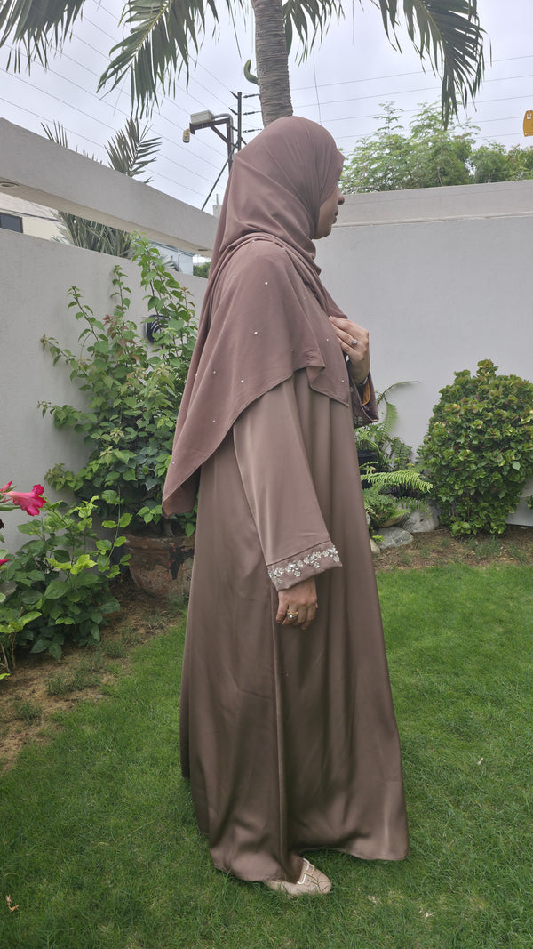 Opal mocha brown abaya in a garden, side view